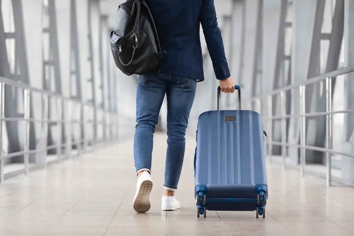 Travel nurse walking through an airport with a suitcase heading to their next travel assignment