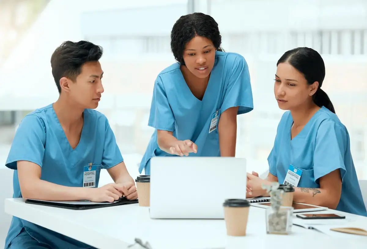 Group of per diem nurses working at a laptop in a meeting room